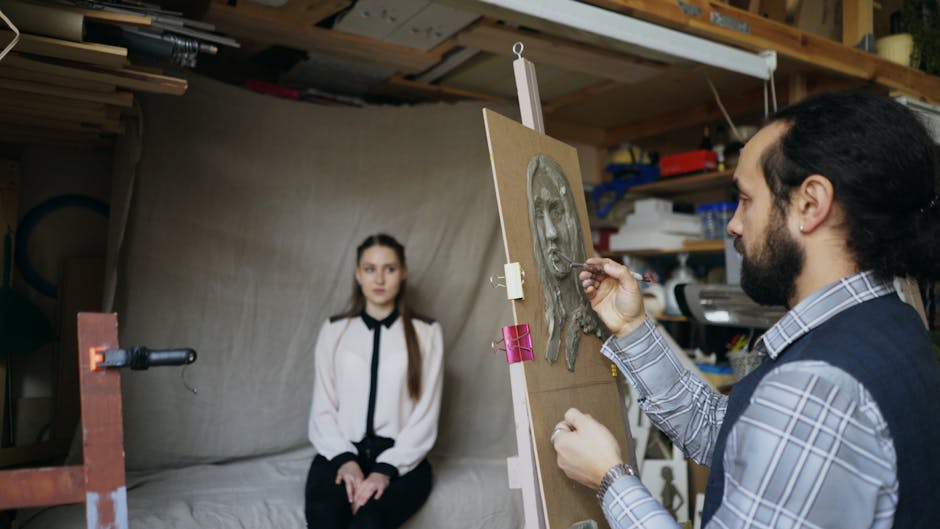 A sculptor works on a clay portrait in an art studio with a female model.